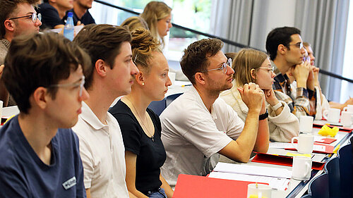 Junge Frauen und Männer sitzen im Hörsaal und folgen konzentriert der Vorlesung.